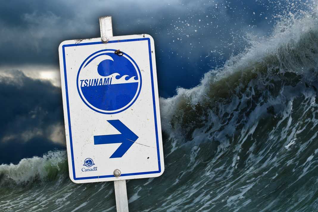 Ein Tsunami-Warnschild, das die Fluchtrichtung anzeigt.