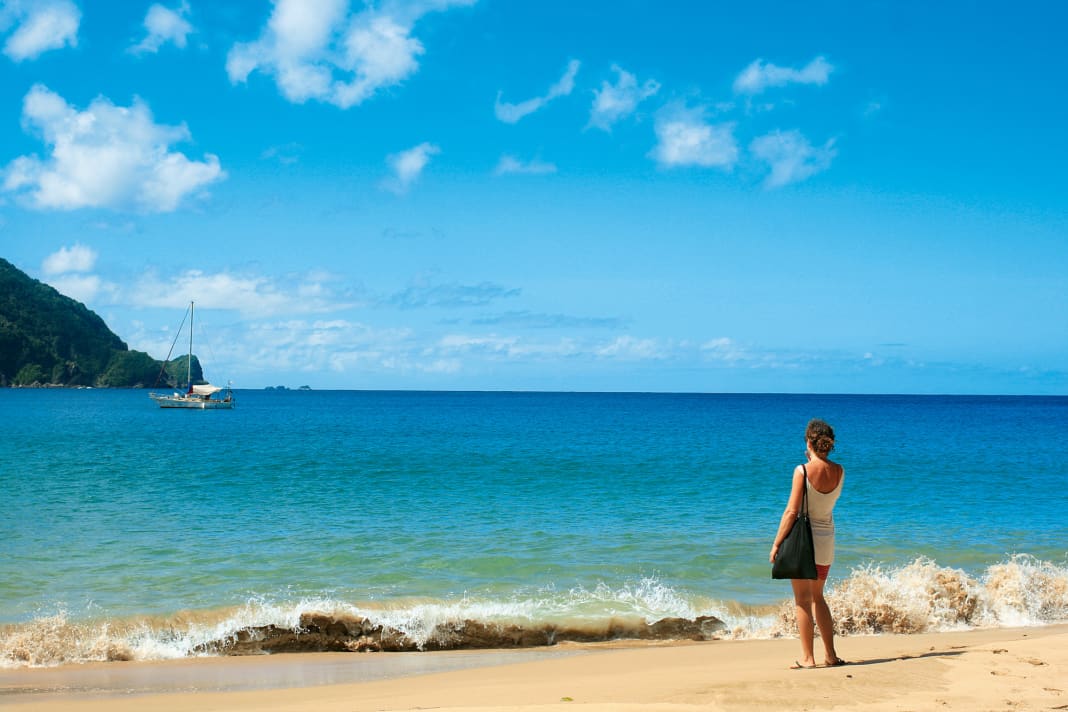 Angekommen. Claudia Clawien blickt vom karibischen Sandstrand der Pirate’s Bay von Tobago aus auf ihre dort vor Anker liegende stählerne Segelyacht „Inti“