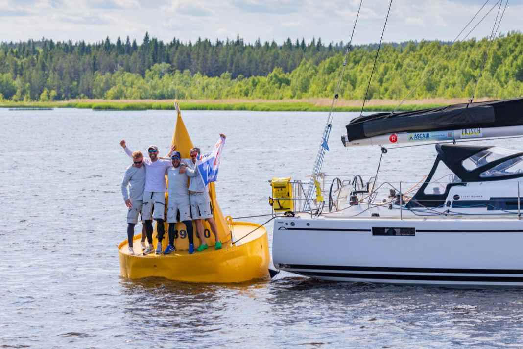 The "Lightworks" crew led by Michael Höfgen celebrates crossing the finish line at the MidsummerSail on the legendary yellow Töre buoy.