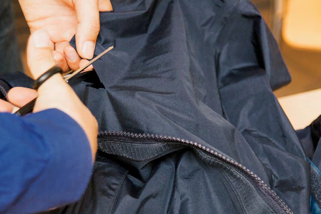 La bavette derrière la fermeture éclair du pantalon ne contribue guère à l'étanchéité. Ici, on découpe le patch correspondant