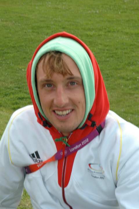   Simon Grotelüschen in team clothing on the meadow in front of the Olympic Village