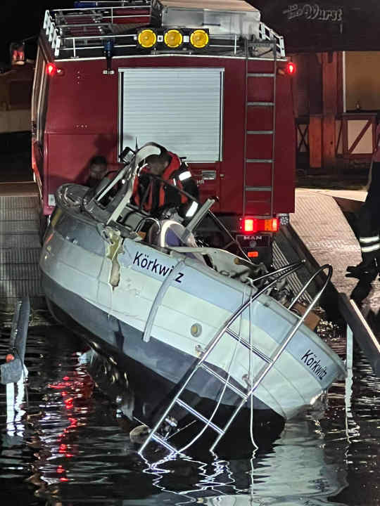 Recovery of the cabin cruiser, the site of the impact can be seen on the side.
