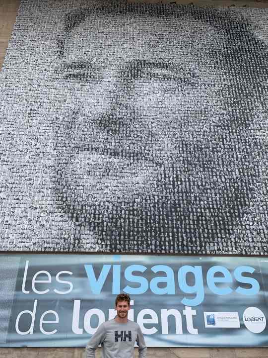  Désormais lui-même l'un des visages de Lorient ("Les visages de Lorient") : Le mini timonier Lennart Burke devant la mosaïque de photos d'Eric Tabarly à "La Base" à Lorient