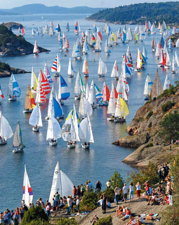 Das Regattafeld von Tjörn Runt quetscht sich durch den Kyrkesund, die Engstelle ist die perfekte Tribüne, an Land herrscht Volksfeststimmung