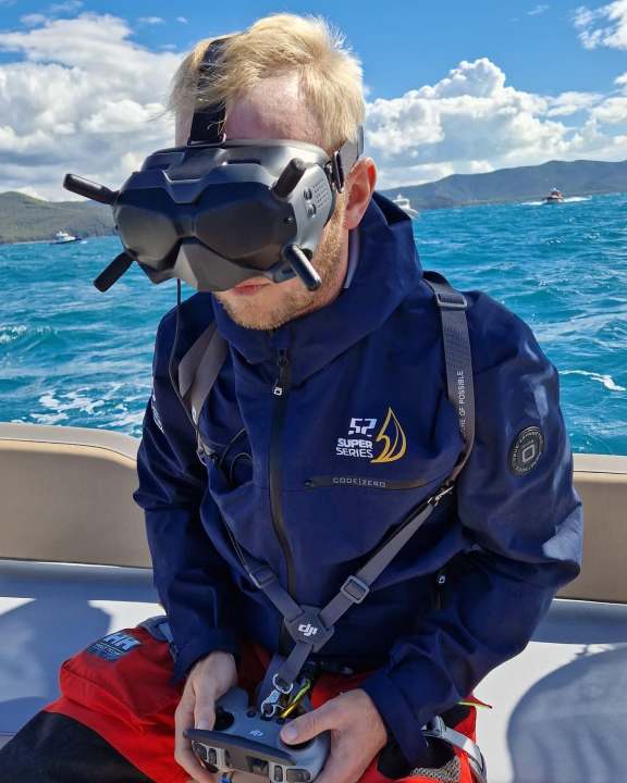 So sieht Drohnen-Pilot Eike Schurr bei der Arbeit aus. Die Brille lässt ihn die Piloten-Position einnehmen. Ein Assistent informiert zeitgleich über die Entwicklungen auf dem Kurs