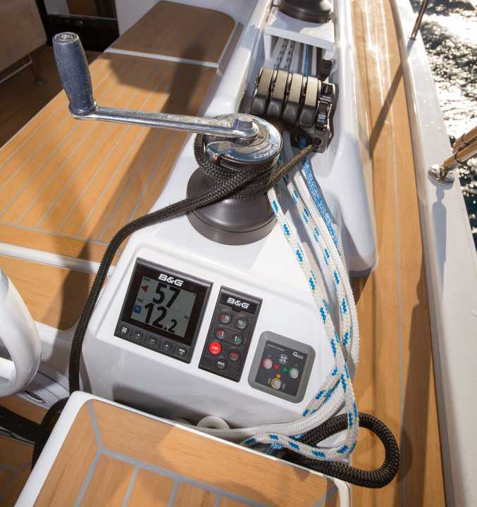 The lines disappear into storage boxes. Instruments and the control panels for the autopilot and bow thruster are mounted on the coaming