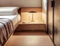 Lots of wood: the strictly parallel groove structure of the ceiling panels is echoed by the fronts of the bedside table and the sliding window panels