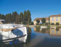 The Pénichette Neo from Riverly against the picturesque backdrop of Le Somail on the Canal du Midi.