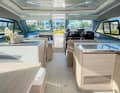 The spacious saloon of the Aquila 42 extends across the entire width of the boat. Light wood tones create a pleasant atmosphere. The large roof can be partially opened, transforming the power catamaran into a convertible.
