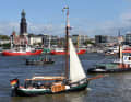 Traditional sailing ship in front of the panorama of the Landungsbrücken with the Michel in the background