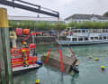 Das gekenterte Motorboot wird mit Hilfe eines Feuerwehrkrans gedreht.