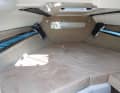 The dimensions of the sleeping area promise space for two. The headroom is due to the design (day cruiser). A toilet is located at the very front on the starboard side