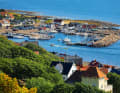View from the wooded heights of the Kullaberg down to the harbour of Mölle. It is early afternoon. Those who arrive in the evening can look forward to a place in the packet