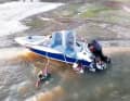 Four people cling to the boat right at the spillway edge of the dam.