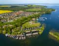 Blick vom Röbeler Binnensee über Bootshäuser und die Stege der Marina Röbel mit der Müritz im Hintergrund