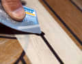 Zum Abziehen eignet sich auch eine alte Bankkarte. Das Klebeband nach dem Aushärten entfernen. Dann überschleifen