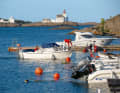 Local boats in front of the Lyngør Fyr lighthouse