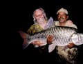 Zum Angeln nach Indien: Terence Disdale präsentiert einen von ihm gefangenen Mahseer, einen karpfenartigen Fisch mit riesigen Schuppen.