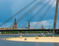 Blick über die Düna auf das Zentrum Rigas, gesehen von der Marina. Im Vordergrund der Kipsala-Strand, dahinter die Vanšu-Brücke. Im Hintergrund von links die Türme des Doms, der Petrikirche und der Akademie der Wissenschaften, eines Baus aus Sowjetzeiten