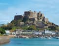 Jerseys älteste Burg Mont Orgueil Castle (um 1200 gebaut) mit dem Ort Gorey zu Füßen – eine beinahe mediterrane Postkartenidylle. Das Foto ist bei Hochwasser aufgenommen, bei Niedrigwasser fällt der Hafen vollständig trocken