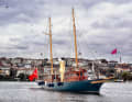 The yacht makes its way along the water under a waving Turkish banner and against the densely built-up backdrop of Istanbul.