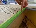 After sanding, the deck is cleaned with an industrial vacuum cleaner. Then carefully mask off all open edges, such as here on the anchor locker. The epoxy paste would otherwise run out of the open joints