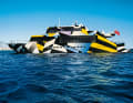 35 Meter Pop-Art: Das  Konzept von Jeff Koons für die Lackierung von Rumpf und Aufbauten zitiert die Tarnungsmethode der Marineschiffe aus den Weltkriegen. Die Palette reduzierte Koons auf sieben Farben.