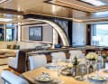 One saloon, three compartments: The TV monitor with two fireplaces separates the lounge aft from the dining area forward on the main deck.