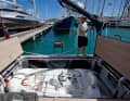 The crew stows the tender in the stern.