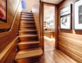Treppe: Unten geht es backbords in die nahezu neun Meter breite Eignersuite. Auch im Flur hängt viel Kunst. Die Treppenbrüstung zeigt die Dimensionen des 1,10 Meter hohen Zwischendecks.