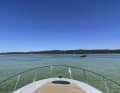 Platz 15: Startklar von Sabine Lange, Starnberg: Saisoneröffnung am Starnberger See. Voraus die Roseninsel. Das Halbrund der Bugreling füllt den Vordergrund aus und lenkt den Blick weiter übers Wasser zur Uferzone. Der Farbkontrast zwischen blauem Himmel, grünlichem Wasser und weiß-beigem Deck sorgt für eine schöne Bildstruktur.