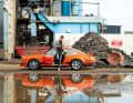 Zwei Welten: Die staubige Industriebrache in Frankreich als perfekte Fotolocation für den frisch restaurierten 911 Carrera RS 2.7 in leuchtendem Blutorange.