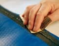 Roughen the surface to be covered with sandpaper.