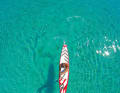 Relaxed cruising: If you pull on the bar in a relaxed manner, you use the perfect paddle pull technique (secrets 1 to 3), but you don't have to use your body as much to paddle effectively (secrets 4 and 5).    Secret 4: The formula is simple: if you paddle correctly, you will make good progress - even when cruising at a relaxed pace. The secret: The paddle shaft must always be dipped as vertically as possible into the water when catching. The pommel hand (upper pressure hand) is directly above the shaft hand (clearly visible in the picture). If the technique is incorrect and too casual, the pommel hand would be over the other half of the board and the shaft at the wrong angle. If the shaft is not plunged vertically, the blade cannot be pulled straight and effectively backwards.