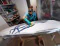 The resin is carefully worked into the glass fabric.