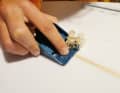 Beim Schleifen mit Schleifpapier bleibt der Stringer vorgewölbt. Um hier Schwachstellen im Laminat zu vermeiden und für eine schön glatte Fläche wird dieser mit einem Taschenhobel (Tipp: Minihobel mit Rasierklingen aus dem Baumarkt) vorsichtig abgehobelt. Zum Einstellen den Hobel auf eine Glasplatte stellen, unter die Vorderkante ein Blatt Papier legen, die Rasierklinge locker ausrichten, festziehen, fertig ist das Präzisionsinstrument.