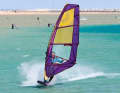 Initiate a leeward turn by applying moderate pressure on the leeward edge and keep your body upright above the board.