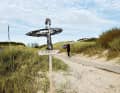 Surfer weisen den Weg durch Föhrs schöne Dünenlandschaft.