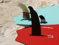 Tabou (green, back) has a classic thruster set-up for all board sizes. The fin on the Starboard Kode (red) is installed very far forward in the board, which suggests that a thruster set might be the more suitable equipment.