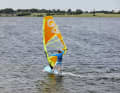 4) Hold as tight as possible with your sailing hand, hang your body weight in the sail and shift your weight to your back leg, as the sail pull naturally increases noticeably during the drop. You will notice that your board is accelerating - no wonder, because the space wind course diagonally away from the wind is the fastest course in windsurfing.