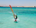 As you switch to the other side just below the outhaul (rear corner of the sail), slide your back hand far back (wide grip)