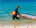 1 To start, set your board half-windward (crosswind) and grip the mast with your front hand directly above the boom.