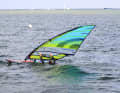 Um zu verhindern, dass dir das Gabelbaumende im Wasser stecken bleibt und sich dein Board ungewollt in den Wind dreht, ziehe den Mast mit dem vorderen Arm aktiv nach Luv, das Gabelbaumende kommt dadurch frei.