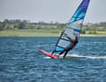 Error analysis - tail loading: Modern boards react more sensitively to incorrect loading of the tail due to their reduced length. We have highlighted the most common mistake in the planing phase here: When moving the front foot into the loop, the entire body weight briefly rests on the back leg, the bow comes up, the board brakes and turns into the wind. If this happens to you, your path is: boom up, tilt your upper body forwards past the sail and put weight on the base plate via the harness lines.