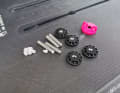 The FoilFix set consists of stud bolts, small spacers (white) for adjusting the bolt length, the nuts (black) and a small tool (pink)