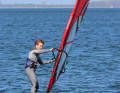 Damit dir das Board in dieser Phase nicht unkontrolliert steigt und das Foil den Kontakt zum Wasser verliert, versuche die Flughöhe bewusst niedrig zu halten. Dies gelingt, wenn du den Mast durch das Strecken des Mastarms konsequent weg vom Körper und nach vorne in Richtung Bug schiebst.
