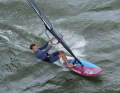 At full planing speed on a half-wind course, first take your back foot out of the loop and grip the boom as far forward as possible with your front hand.