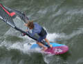 The moment the new front hand grips the boom, the old one lets go. Now pull the sail past your body to windward. The rear leg must give way to the mast at this moment and swings forwards in front of the base plate. For a brief moment, both legs are in front of the base plate.