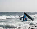 Walk carefully into deep water with the board on your shoulder