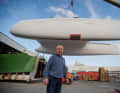 The hull of Jourdain's Outremer 5X hangs in the crane.